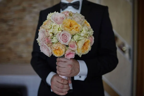 新郎手里拿着一束漂亮的新娘花束 — 图库照片