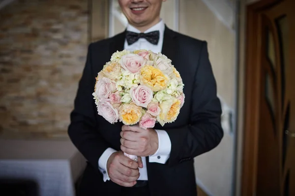 Damat elinde güzel bir gelin buketi tutuyor. — Stok fotoğraf