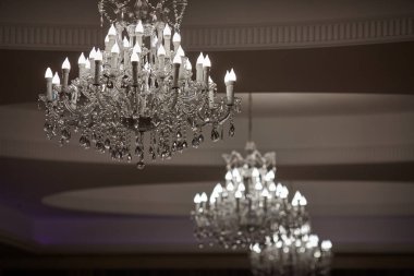  crystal chandeliers with lots of lights in a restaurant