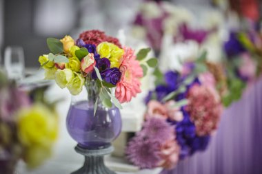 bouquets of various flowers as a decoration on wedding tables