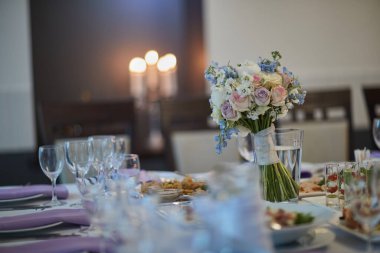 bouquets of various flowers as a decoration on wedding tables