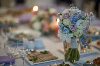 bouquets of various flowers as a decoration on wedding tables