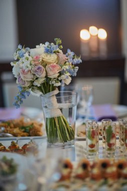 bouquets of various flowers as a decoration on wedding tables