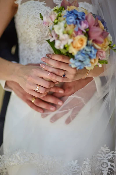 Damat düğün buketini tutan geline sarılır. — Stok fotoğraf