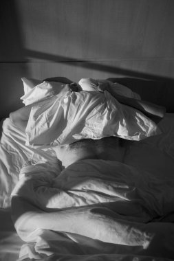 a man lies on a bed at sunrise