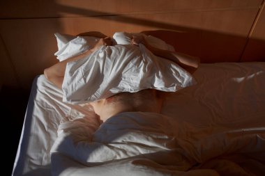 a man lies on a bed at sunrise