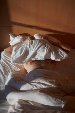a man lies on a bed at sunrise
