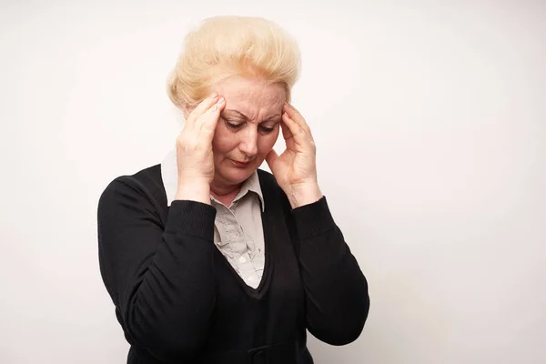 elderly woman hold hands on her sore head