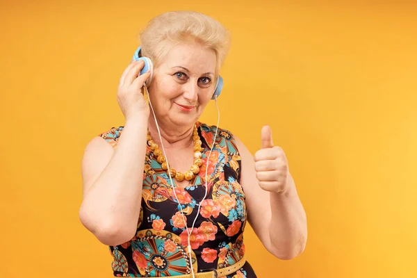 Oudere vrouw luistert naar muziek op koptelefoon Stockfoto