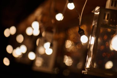 Birçok yanan ışık ve fener sokağı aydınlatıyor.