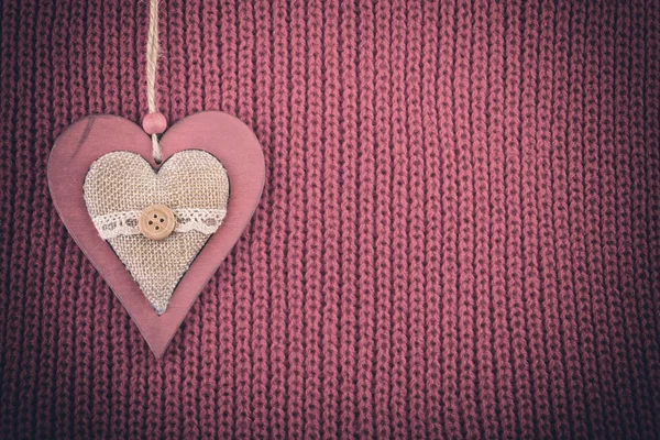 Wood heart on wool knitted fabric. Christmas rustic vintage background pale color vignette — Stock Photo, Image