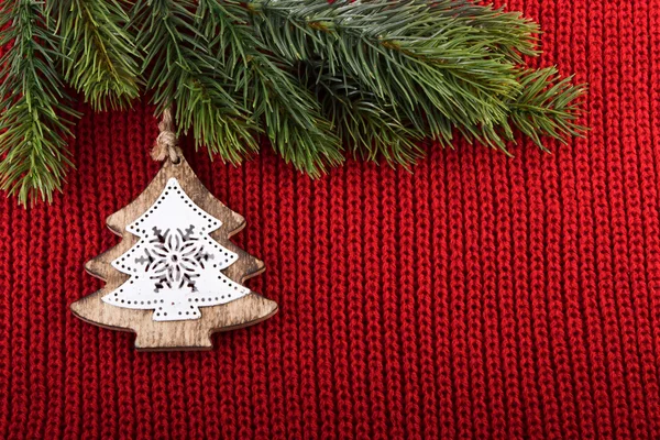 De traditionele decoratie kerstboom op rode wol achtergrond — Stockfoto
