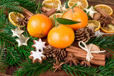 ahşap masa üzerinde köknar dalı ve Noel baharatlar ile mandalina meyve