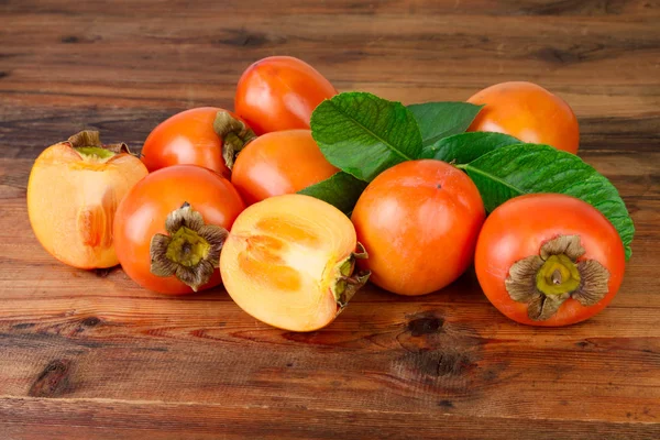 Persimmon. Fruits kaki sur vieux fond en bois — Photo