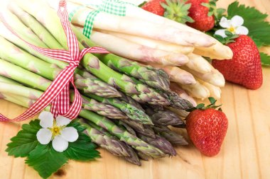 Kuşkonmaz closeup yeşil ve beyaz kuşkonmaz ile ahşap üzerine çilek