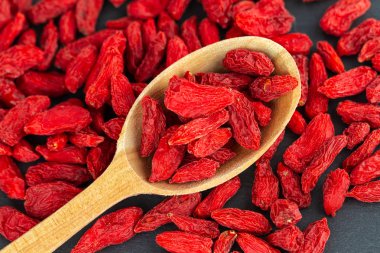 Tahta kaşıkta goji üzümü. Üst manzara, düz uzanma
