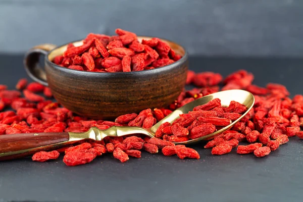 Bacche Goji Una Tazza Cucchiaio Vintage Sfondo Ardesia Grigia Focus — Foto Stock