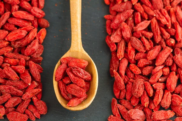 Goji berries over gray slate background. Healthy food concept.