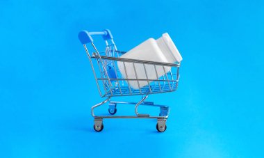 Soğuk algınlığı, grip ve viral hastalıkların tedavisi için ilaç dolu bir sepet ve tıbbi kavanoz. Mavi arka planda tıbbi uyuşturucu, ilaç veya kozmetik ürünleri satın alma kavramı.