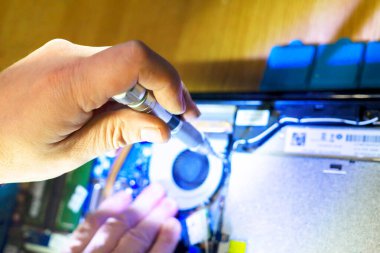 Mühendis laptoyu tamir etmek için tornavida kullanır