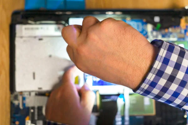 Mühendis dizüstü bilgisayarı tamir etmek için tornavida kullanıyor.