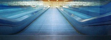 Parlak sarı neon ışığın altında modern metal yürüyen merdivenin yakın çekimi.