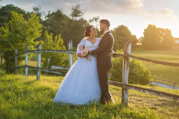 Casamento casal abraçando ao pôr do sol . — Fotografia de Stock