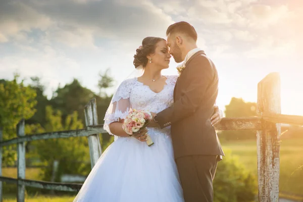 Casamento casal abraçando ao pôr do sol . — Fotografia de Stock