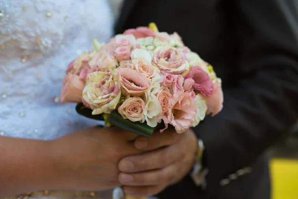 Mãos segurando buquê de flores — Fotografia de Stock