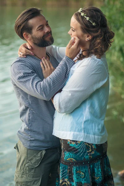 Encantador casal abraçando perto do lago — Fotografia de Stock