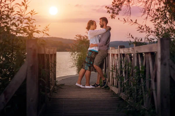 Encantador casal abraçando perto do lago — Fotografia de Stock