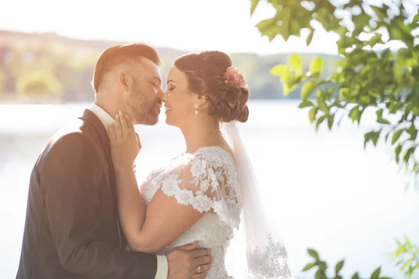 Casamento casal beijando perto do lago — Fotografia de Stock