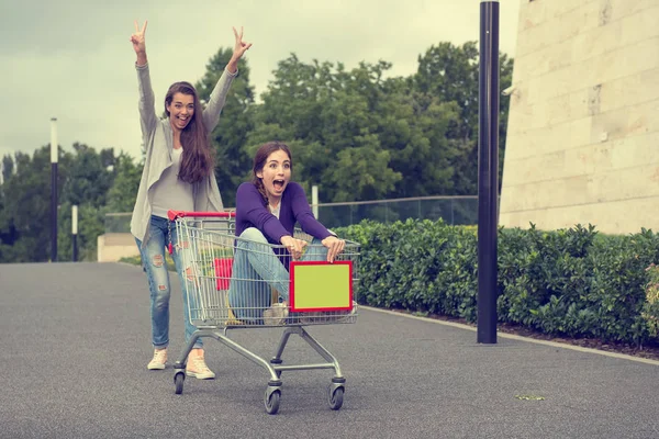 Chicas se divierten con el carrito de compras — Foto de Stock