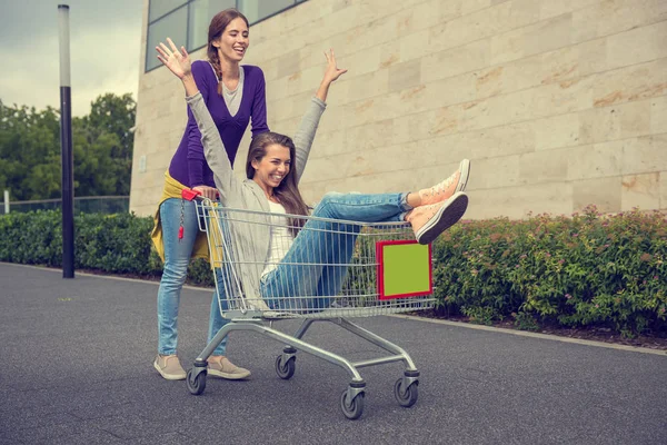 Girls have fun with the shopping trolley — Stock Photo, Image