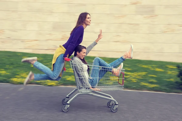 Chicas se divierten con el carrito de compras —  Fotos de Stock