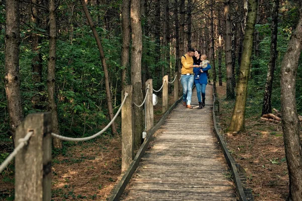 Jeune famille marchant en forêt — Photo