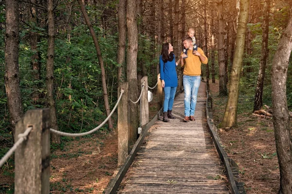 Молодая семья гуляет по лесу — стоковое фото