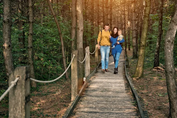 Jovem família caminhando na floresta — Fotografia de Stock