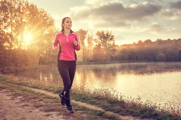 Vrouw joggen op lake — Stockfoto