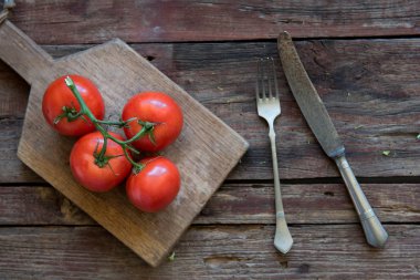 Fresh tomato on the wood plate clipart