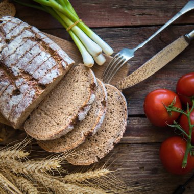 Taze kahverengi ekmek sebze ile ahşap bir plaka üzerinde