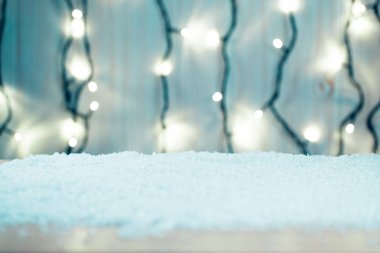 Noel arka plan ile bir aydınlık garland ve kar ahşap masa üzerinde bokeh