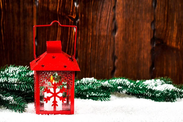 Christmas and New Year background with Christmas candle lantern and Christmas tree branches, snow and decorations, wooden wall behind. Free space — Stock Photo, Image