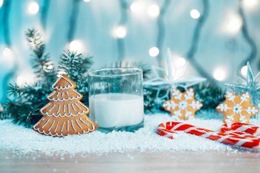Noel kurabiye ve süt ile Dekorasyon, kar, Noel ağacı dalları üzerinde bokeh ışıklar arka plan bulanık. Boş alan