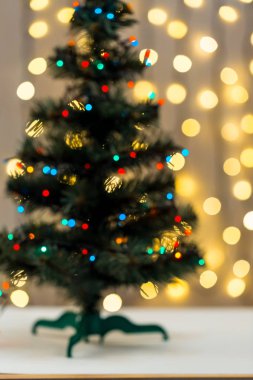 Altın Christmas arka plan de-odaklı ışıklar Garland ile dekore edilmiş ağaç