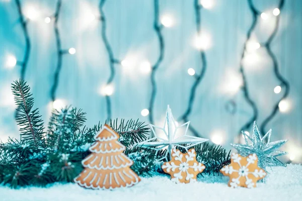 Pão de gengibre de Natal com decorações, neve, ramos de árvore de natal no fundo luzes borradas bokeh. Espaço livre — Fotografia de Stock