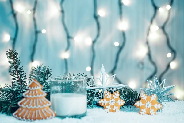 Pane di zenzero di Natale e latte con decorazioni, neve, rami d'albero di Natale su sfondo bokeh luci sfocate. Spazio libero — Foto Stock