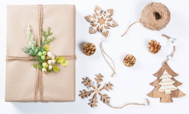 Klas Noel hediye kutusu kahverengi kağıt oyuncaklar ve yılbaşı dekor beyaz sunar. Neşeli Noel kartı arka plan