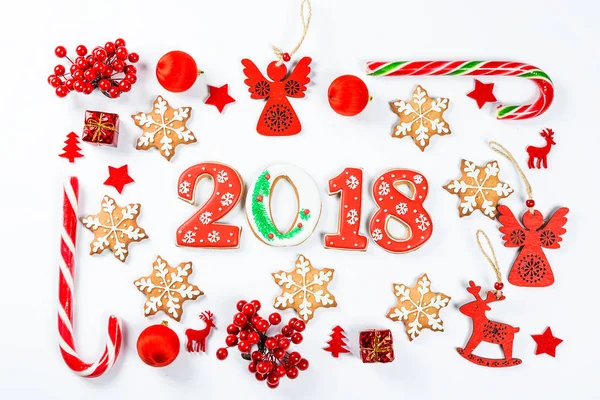 Moldura de Natal feita de brinquedos vermelhos e decorações de Ano Novo com biscoitos de gengibre 2018 no fundo branco. Deitado plano, vista superior, espaço de cópia. Feliz cartão de Natal — Fotografia de Stock