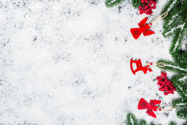 Fundo de Natal com flocos de neve, neve branca, brinquedos, doces, galhos de árvore de Natal e decoração de Ano Novo. Moldura de férias de inverno — Fotografia de Stock